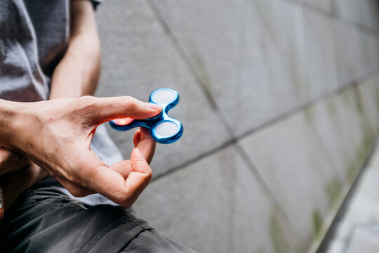 Asian man playing with a fidget spinner