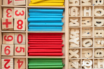 Colored pencils, red numbers and wooden Letters a Wooden Box