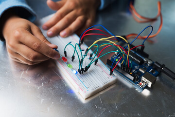 Boy connecting electronical parts to create his first little robot
