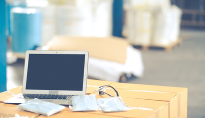 Face mask, Laptop computer and goggle on Packing box at warehouse. Online marketing, startup SME, freelance