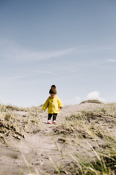 Young toddler walking on sand in winter