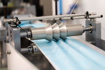 Machines are working for producing masks in a sterile factory. Production of medical masks. process of manufacturing a mask