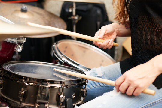 Unrecognizable drummer playing music.