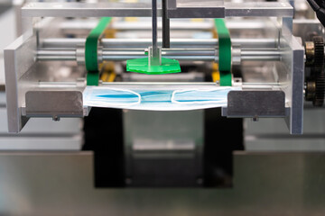 Machines are working for producing masks in a sterile factory. Production of medical masks. process of manufacturing a mask