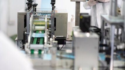 Machines are working for producing masks in a sterile factory. Production of medical masks. process of manufacturing a mask