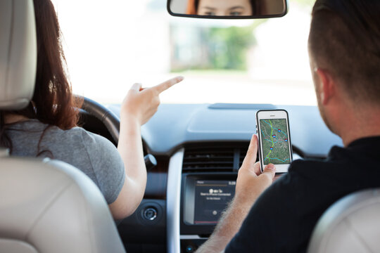 Driving: Father Directing Girl Driver Using Satellite Map On Cel