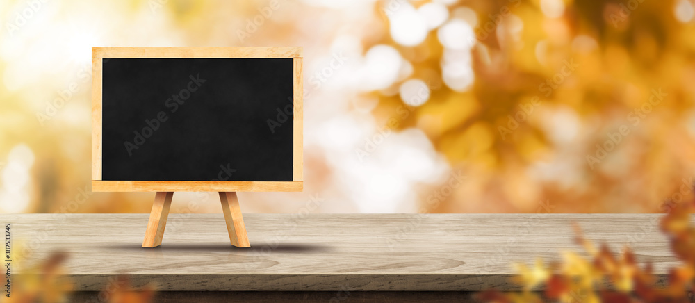 Aufkleber autumn background.blank desktop computer on rustic wood table with blur forest tree with sunlight,au