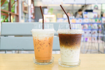 Ice latte coffee and ice Thai tea on wooden table in the cafe