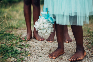 Black flower girl's feet on a path outdoors