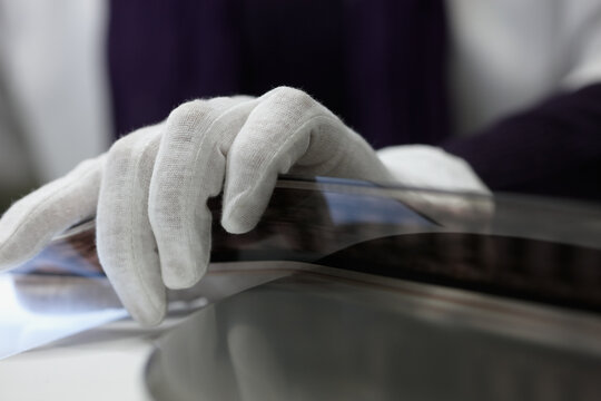 Close up of a gloved hand manipulating negative motion film