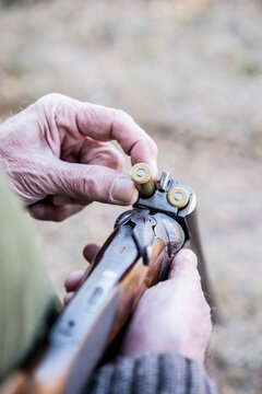 Old man putting ammunition in a hunting rifle-(loading shotgun)