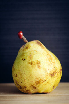 Yellow pear with red seal on black background