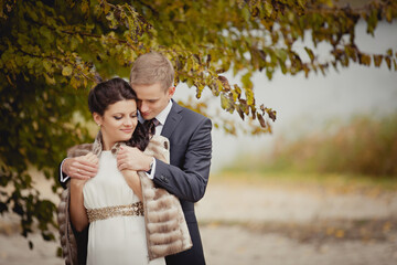 couple on autumn walk outdoors. Two lovers in autumn park. Love and tender touch. Autumn wedding