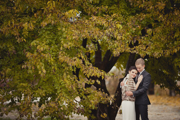 couple on autumn walk outdoors. Two lovers in autumn park. Love and tender touch. Autumn wedding