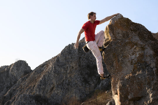 Young man bouldering at sunset