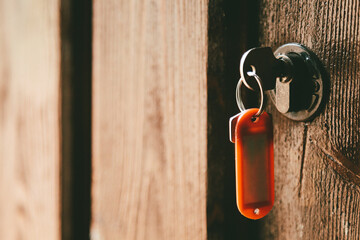 Rusty Key on an Old Wooden Door with a Red Tag