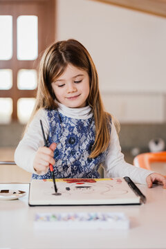 Young girl drawing at home