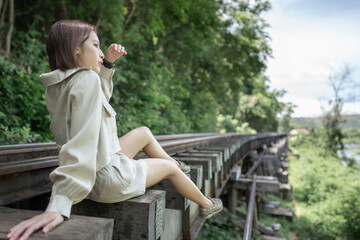 Close up of woman sitting on vintage railroad, railway tracks in a rural scene.