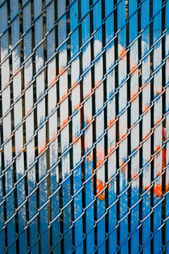 Blue chain-link fence and paint covering graffiti markings