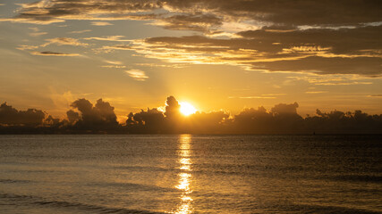 Fototapeta na wymiar Sunrise shot over the sea and beautiful cloud. sun disappeared behind a big cloud over ocean.
