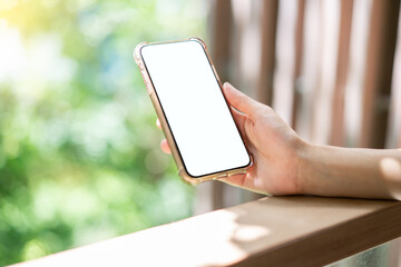 Woman hand holding mobile phone with blank white screen mockup.