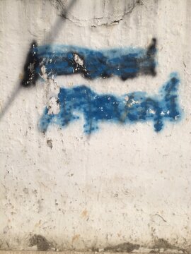 Smudged street graffiti on a wall.