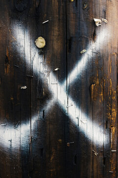 X spray painted onto telephone pole, close up