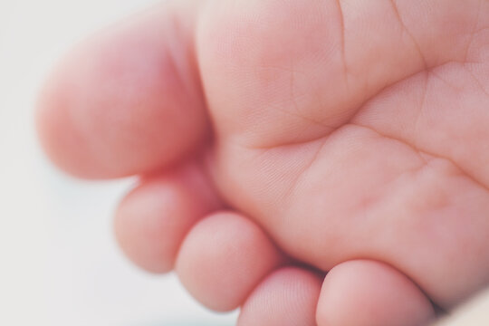 Closeup shot of details of wrinkles on newborn baby's toes and sole