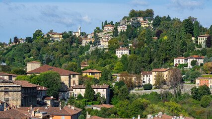Naklejka premium Bergamo, Italy. View of the hills that surround the old town of Bergamo. Homes surrounded by greenery. City green contest. View of San Viglio hill