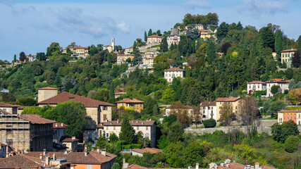 Fototapeta na wymiar Bergamo, Italy. View of the hills that surround the old town of Bergamo. Homes surrounded by greenery. City green contest. View of San Viglio hill