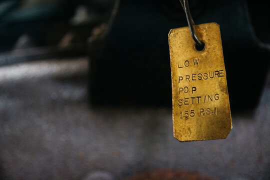 Brass label on a valve indicating low pressure setting