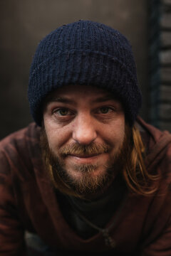 Portrait of young homeless man looking at camera with hopeful eyes