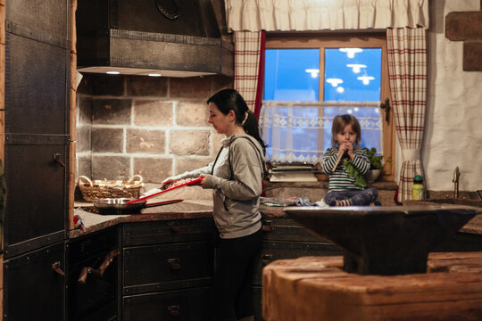 mother cooking in cast iron kitchen while son is watching
