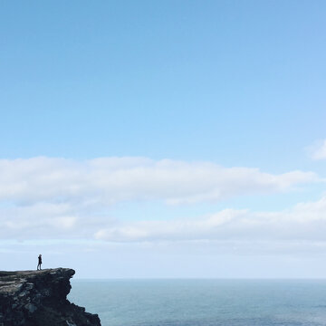 Lone girl standing on a cliff
