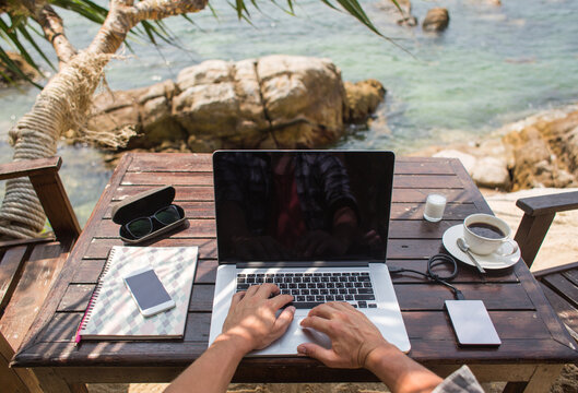 Man working on his laptop with a sea view
