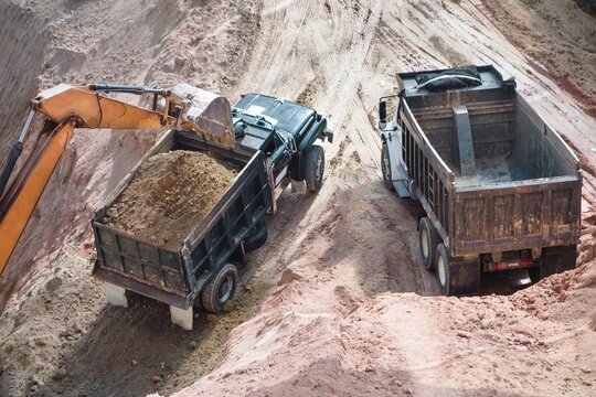Two trucks and an excavator at construction site
