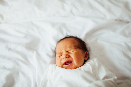 a newborn baby girl getting a little grumpy