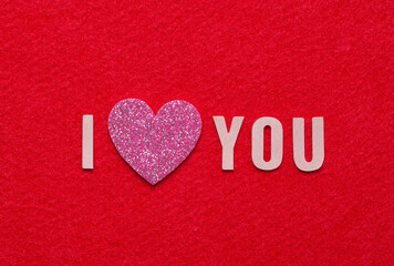 Fototapeta premium Message I love you spelled in leather alphabet and pink glitter heart with copy space.