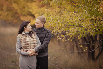 Fototapeta premium couple on autumn walk outdoors. Two lovers in autumn park. Love and tender touch. Foggy cloudy day filled with the warmth of love. Beautiful autumn landscape for couple