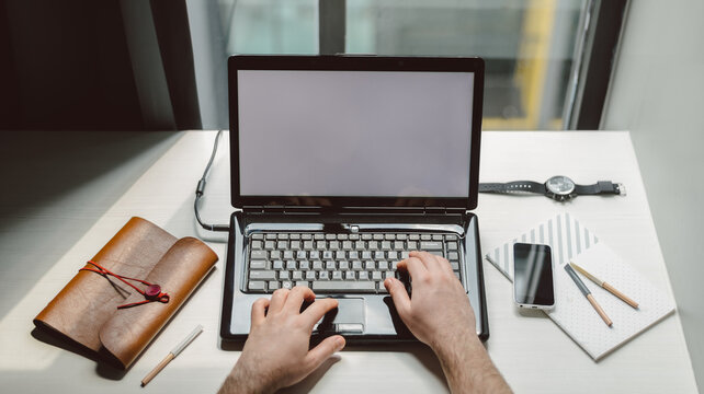 Close up of a man's hands typing on the laptop