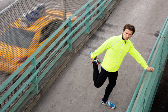 Male runner stretching by the FDR in NYC