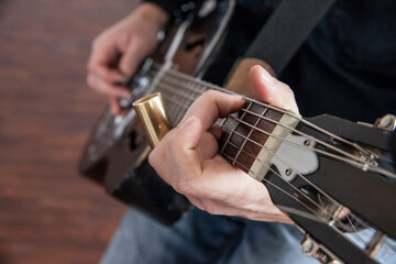 hands holding and playing the resenator dobro guitar