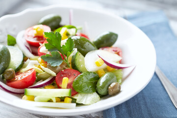 Healthy Salad with Green Olives, Baby Spinach, Cucumber, Cherry Tomatoes and Capers. Bright background. Close up.	