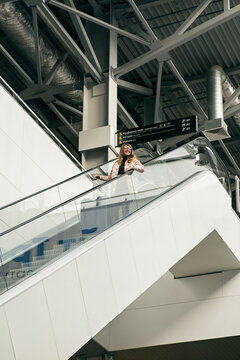 Smiling woman on escalator in airport