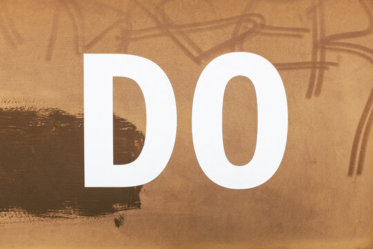 The word "DO" written on rusty, metal wall, close up