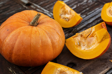 Orange pumpkin on a wooden rustic garden table. Fall background.