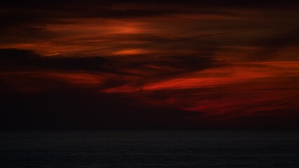 Naklejka na ściany i meble Sunset over sea. Dark sky