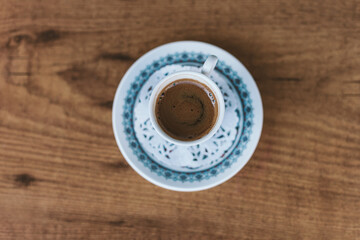 Turkish coffee cup on wooden table. Top view. Tradicional arabic serving. Copy space. 