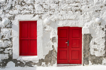White facade with red door and window
