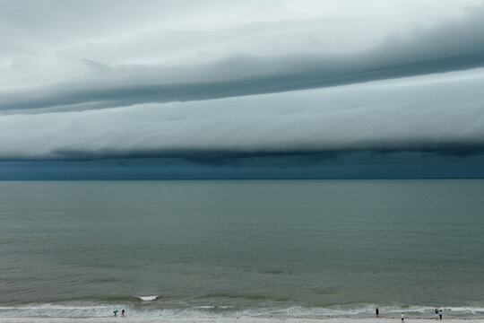 People on beach watching a tropical storm come in
